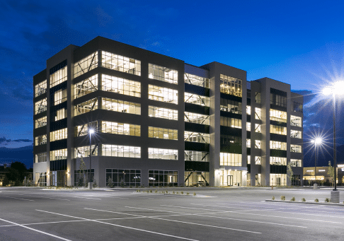 Outside view of an office being built at night with all of the lights on