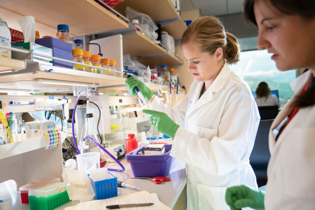 two scientists working at a bench in a lab