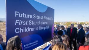 People standing in front of a sign unveiling Nevada's First Standalone Children's Hospital